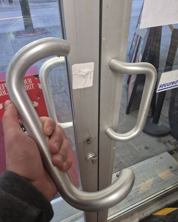 Ladder-pull handle on a glass storefront entry door