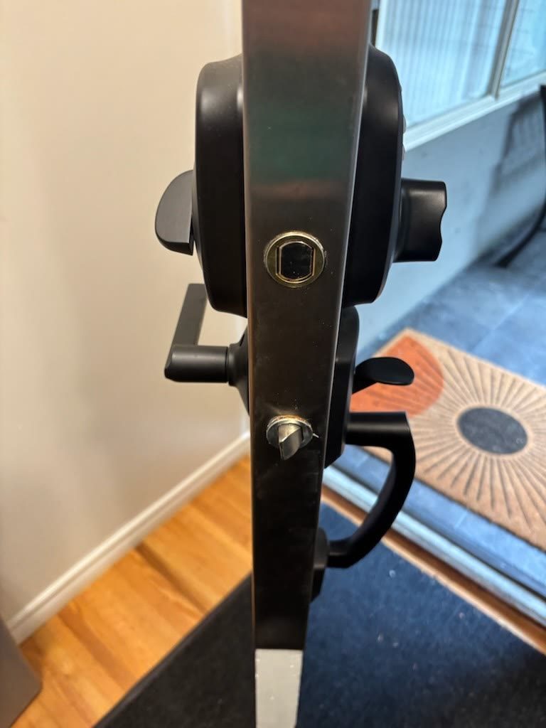 Matte black lever handle and multipoint lock hardware on the edge of a glass patio door