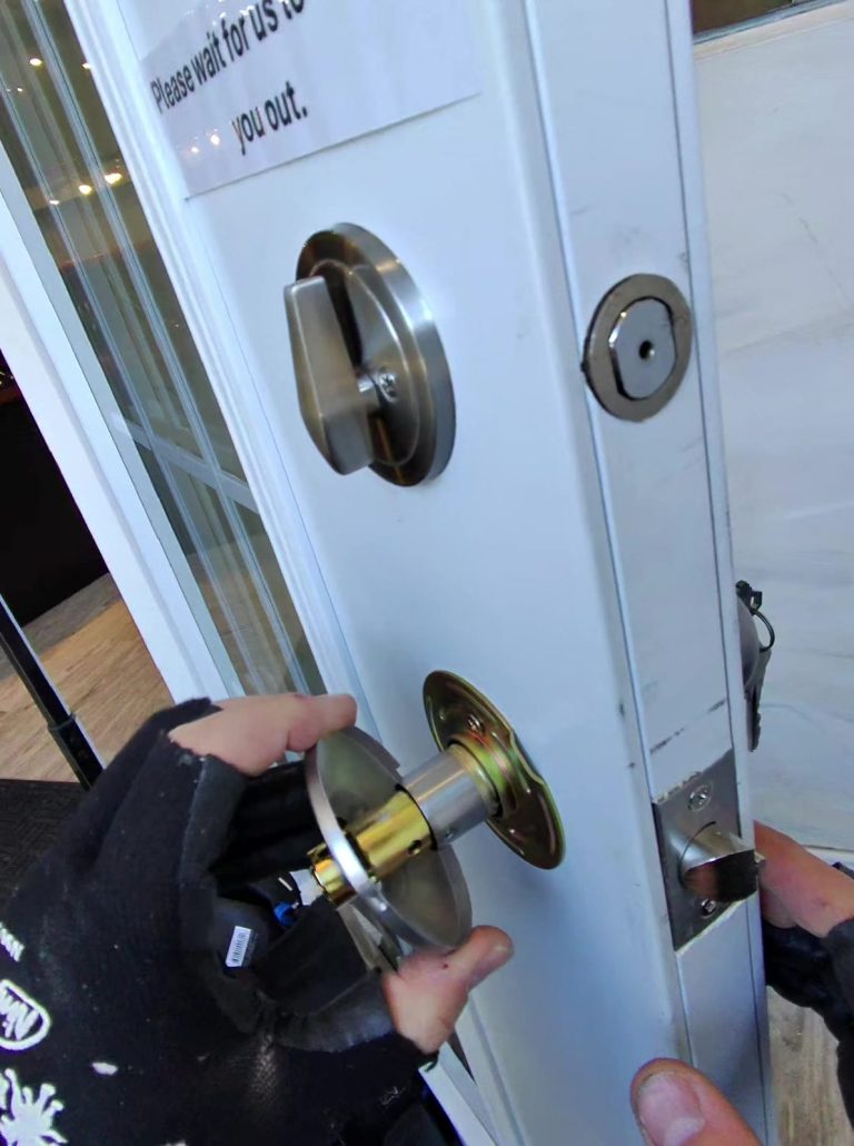 New satin nickel deadbolt and knob set installed on a white French-glazed commercial entry door
