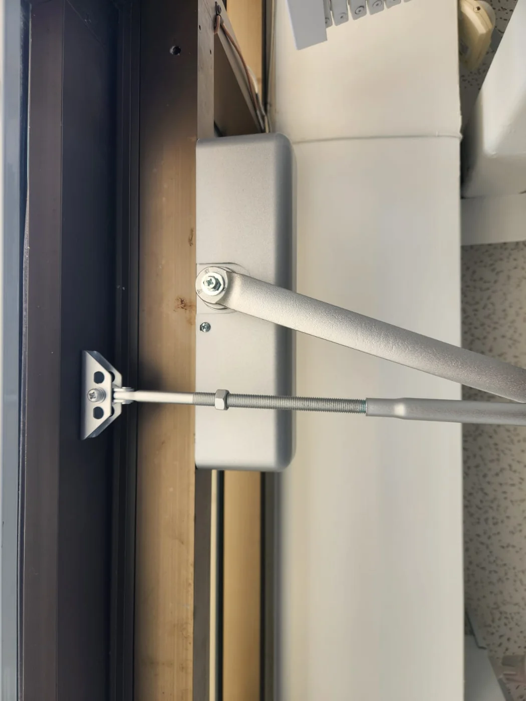 Commercial door closer arm adjusted by A+ Doors Inc in Vancouver