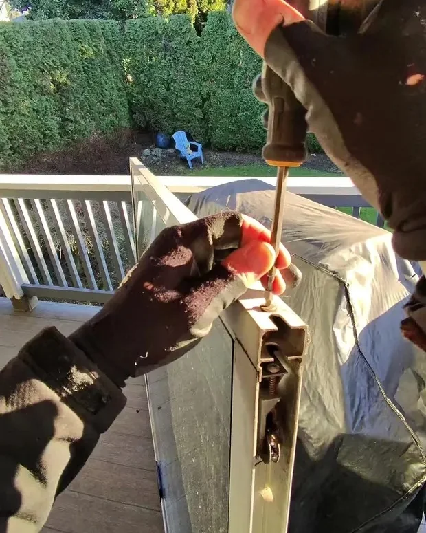 A+ Doors Inc technician repairing a sliding patio door roller in Vancouver